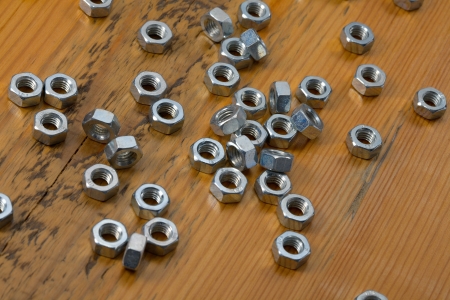 Shiny metal nuts on a tableの写真素材