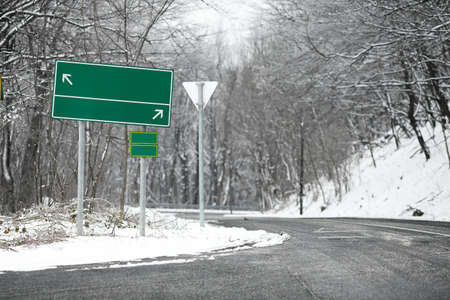 Direction sing on a road in winterの写真素材