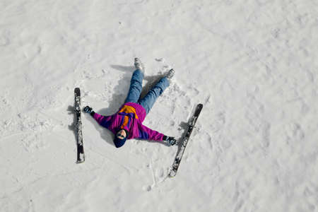 Female skier laying on the snowの写真素材