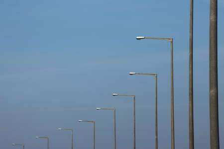Row of street lamps against blue skyの写真素材
