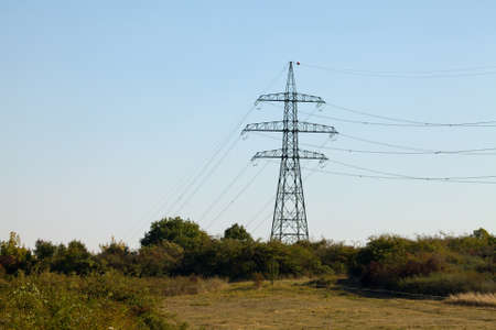 High voltage electricity tower on a hillの写真素材