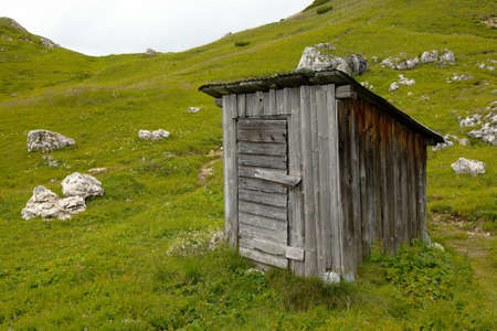 Wooden hut on a green fieldの写真素材