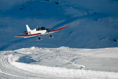 Snowplane landing in the mountainsの写真素材