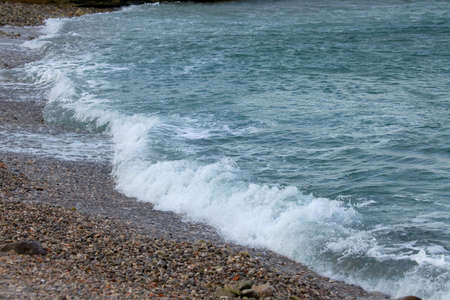 Waves hitting the shore in dull weatherの写真素材