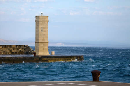 Lighthouse of a small harbor at seaの写真素材
