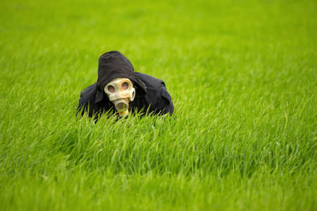 Allergic man in gas mask in the grassの写真素材