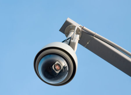 Remote controlled security camera against blue sky