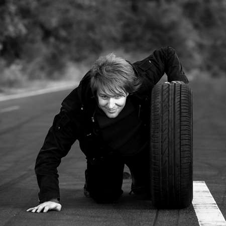 Man holding a wheel on the roadの写真素材