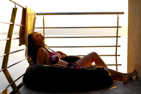Young woman sunbathing on the balconyの写真素材