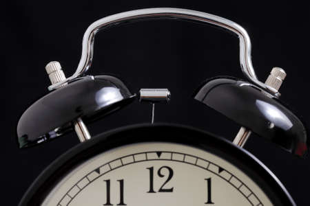 Alarm clock closeup against dark backgroundの写真素材