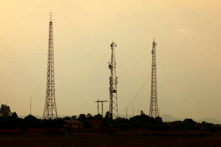 Old radio towers against twilight skyの写真素材