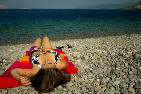 Young woman sunbathing on the beachの写真素材