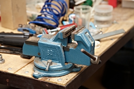 Old vise on a workshop tableの写真素材