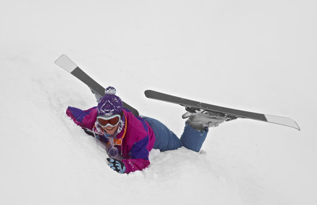 Female skier fallen in deep snowの写真素材
