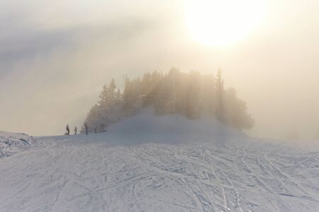 Foggy winter landscape with skiing slopeの写真素材