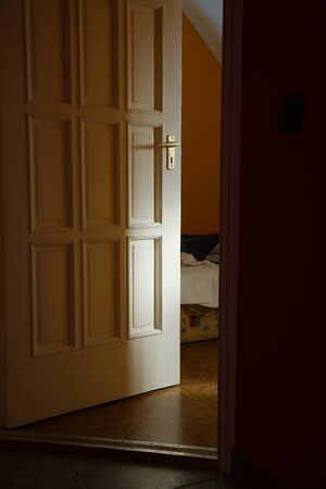 Light coming from a room with door left ajarの写真素材