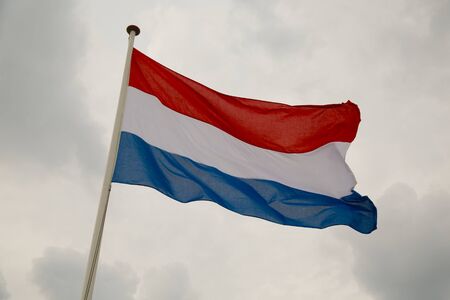 Dutch flag waving against cloudy skyの写真素材