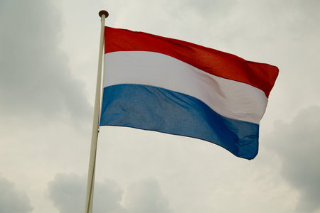 Dutch flag waving against cloudy sky