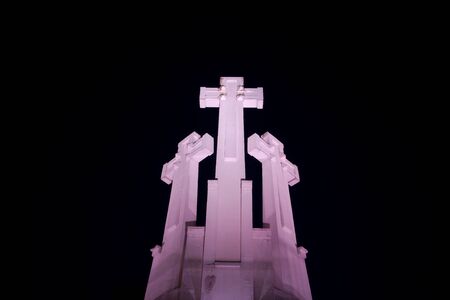 Three crosses illuminated in the nightの写真素材