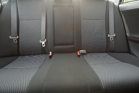 Car interior with back seats, sunlight flaring throughの写真素材