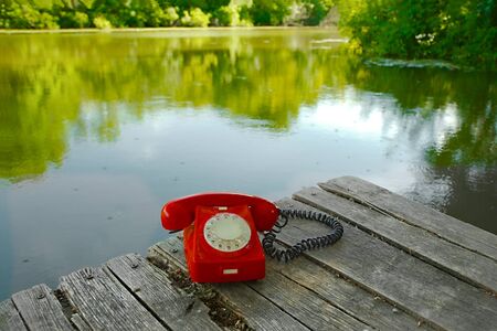 Old telephone on a lakeside pierの写真素材