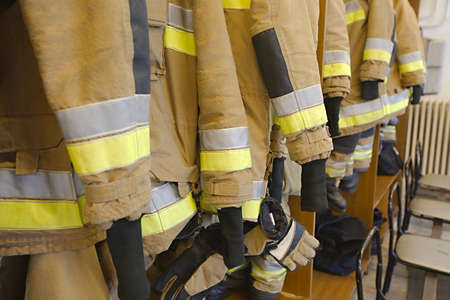 Protective clothes hanging at a fire stationの写真素材