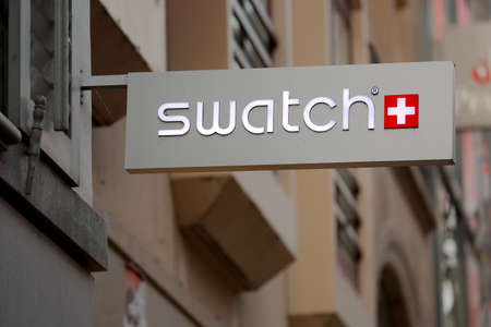 BASEL, SWITZERLAND - JULY 06, 2016: Sign of Swatch on building facade. Swatch is a Swiss watch making company.のeditorial素材
