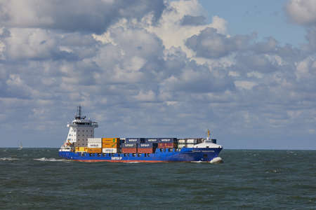 PORT OF ROTTERDAM, THE NETHERLANDS - SEPTEMBER 15, 2017: Industrial ship transporting containers at sea, aprroaching Rotterdam, the busiest cargo port of Europeのeditorial素材