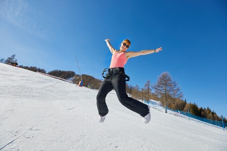 Woman jumping on a ski track in sunlightの写真素材