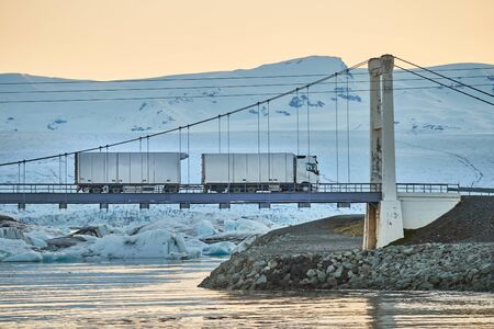 Truck crossing a bridge over an icy lagoon in Icelandの写真素材