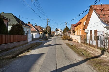 Village street with houses, generic view in Ecser, Hungaryの写真素材