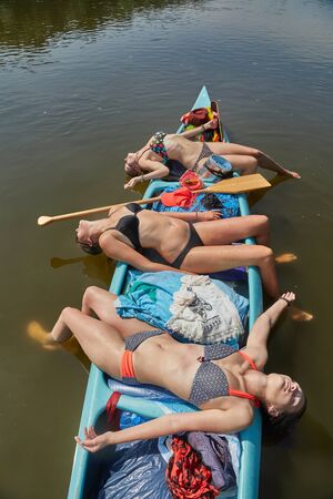 Canoeing on a river, girls in the boatの写真素材