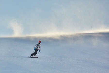 Female snowboarder in sun flareの写真素材