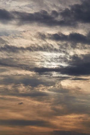 Sunset through cloudy dramatic skyの写真素材