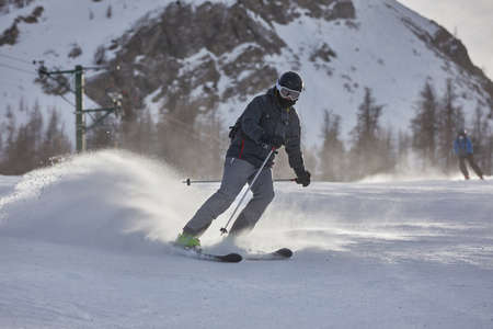 Skiing in the winter snowy slopesの写真素材