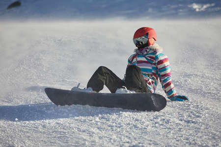 Snowboarder sitting in the snlowの写真素材