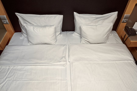 Hotel bed with white sheetsの写真素材