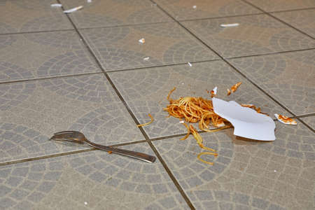 Fallen plate of pasta in the kitchen floorの写真素材