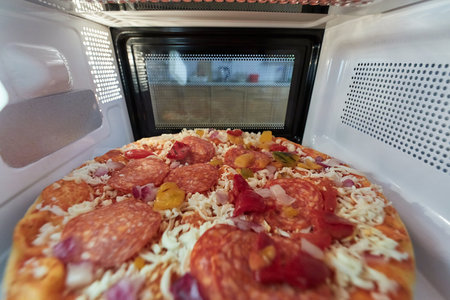 Heating pizza in a microwave ovenの写真素材