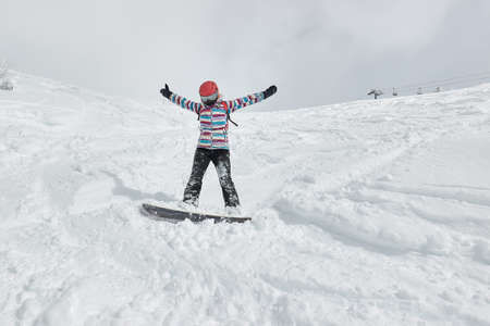 Female snowboarder on the slope, lot of fresh snowの写真素材