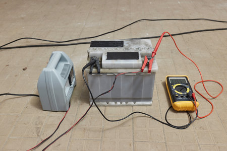 Charging a car starter battery in a garageの写真素材