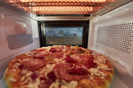 Heating pizza in a microwave ovenの写真素材