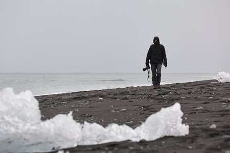 Photographer picking up pieces of icebergsの写真素材