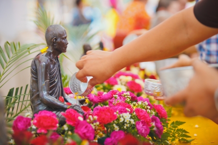 ANG THONG, THAILAND - APRIL 15,2013   Thai people sprinkle water onto a Buddha image and pour water onto monks There are the gesture of worship during the annual Songkran festival at Wat Nangnai Thammikaram on April 15, 2013 in Ang thong,Thailand のeditorial素材