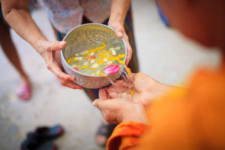 ANG THONG, THAILAND - APRIL 15,2013   Thai people sprinkle water onto a Buddha image and pour water onto monks There are the gesture of worship during the annual Songkran festival at Wat Nangnai Thammikaram on April 15, 2013 in Ang thong,Thailand のeditorial素材