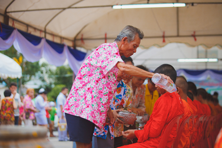 ANG THONG, THAILAND - APRIL 15,2013   Thai people sprinkle water onto a Buddha image and pour water onto monks There are the gesture of worship during the annual Songkran festival at Wat Nangnai Thammikaram on April 15, 2013 in Ang thong,Thailand のeditorial素材