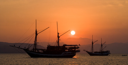 Sailing ship on the sea at sunrise (sunset). Indonesia. Islands. An excellent illustration.の写真素材