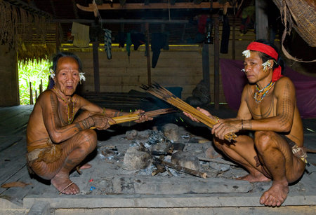 MENTAWAI PEOPLE, WEST SUMATRA, SIBERUT ISLAND, INDONESIA - 03 OKTOBER 2011: Mentawai tribe man sitting at home.のeditorial素材