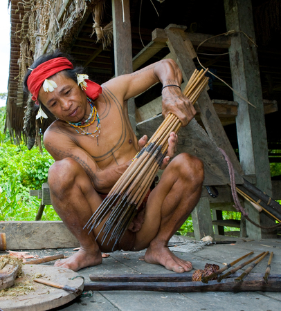 MENTAWAI PEOPLE, WEST SUMATRA, SIBERUT ISLAND, INDONESIA - 16 NOVEMBER 2010: Men Mentawai tribe prepare arrows for hunting.のeditorial素材