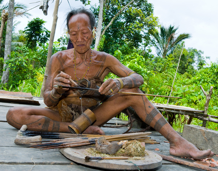 MENTAWAI PEOPLE, WEST SUMATRA, SIBERUT ISLAND, INDONESIA - 16 NOVEMBER 2010: Men Mentawai tribe prepare arrows for hunting.のeditorial素材